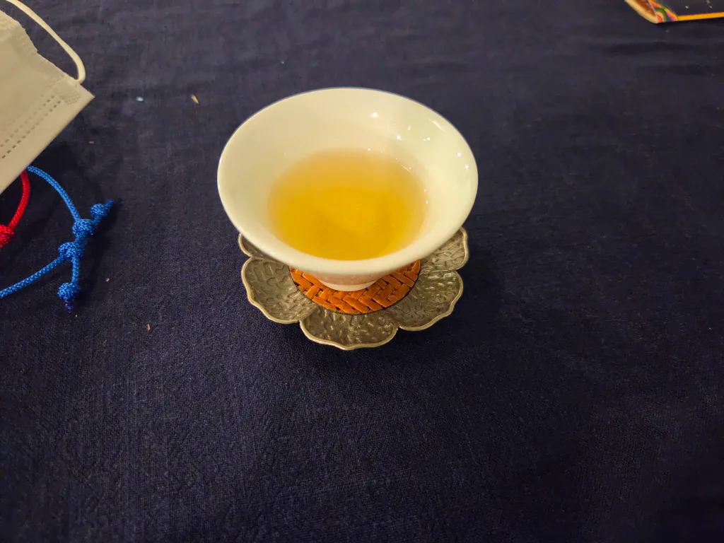 꽃 모양 잔받침 위 하얀 찻잔에 담긴 전통차