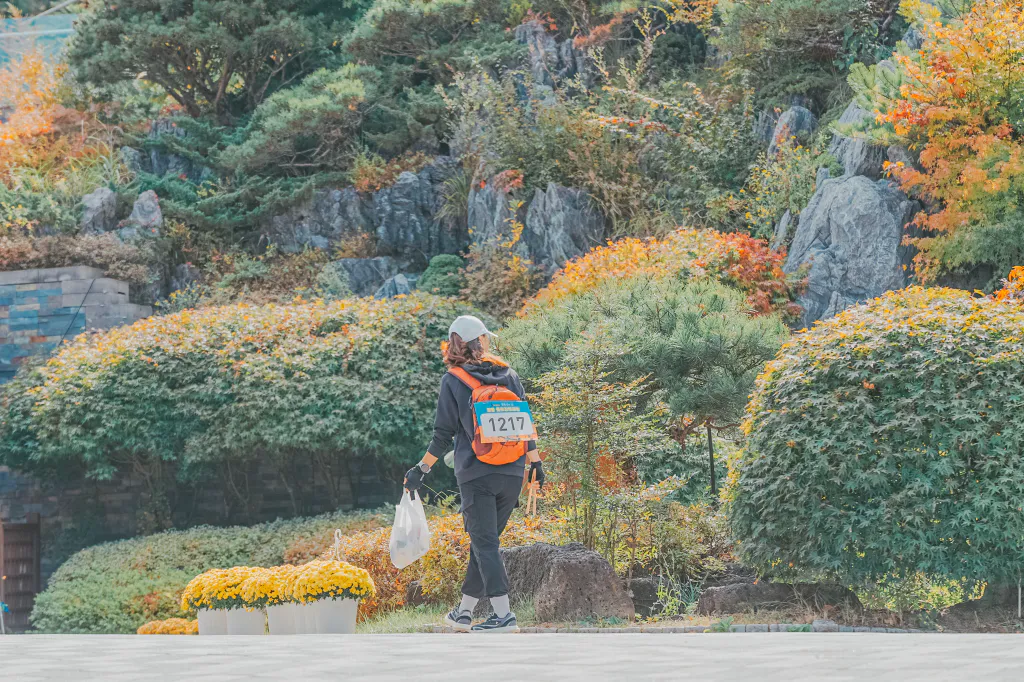 배번을 달고 쓰레기를 주우며 플로깅 중인 참가자