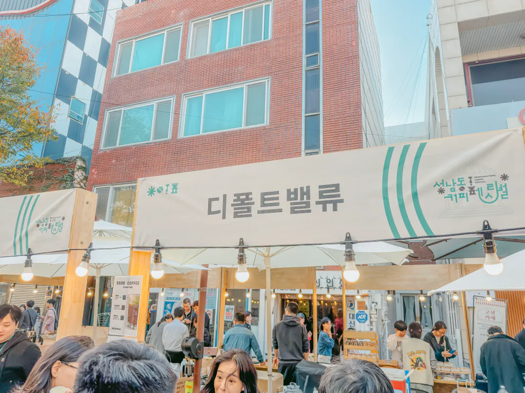 디폴트밸류 부스 간판과 줄 선 사람들